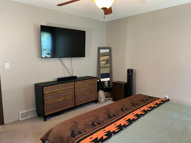 bedroom featuring ceiling fan, a textured ceiling, and light carpet