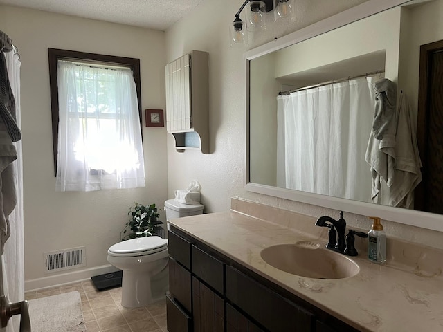 bathroom featuring tile patterned flooring, toilet, a textured ceiling, and vanity