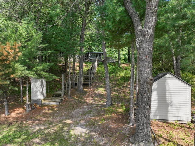 view of yard with a storage shed and a deck