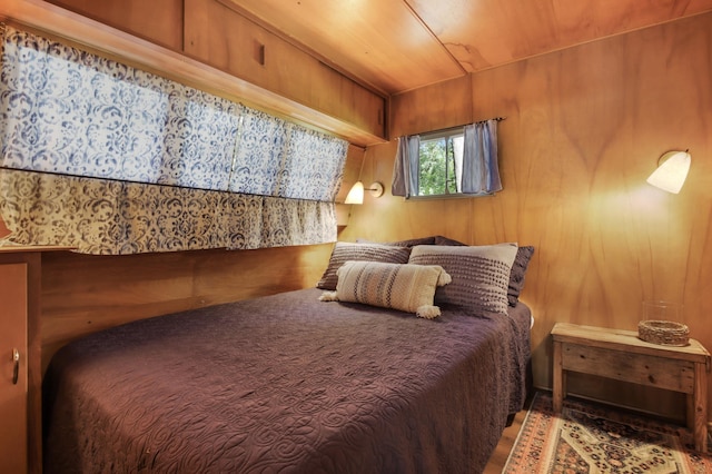 bedroom with wooden ceiling and wooden walls