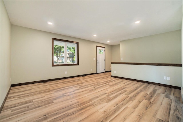 spare room with recessed lighting, light wood-type flooring, and baseboards