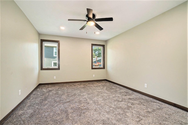 spare room with a ceiling fan, carpet, and baseboards