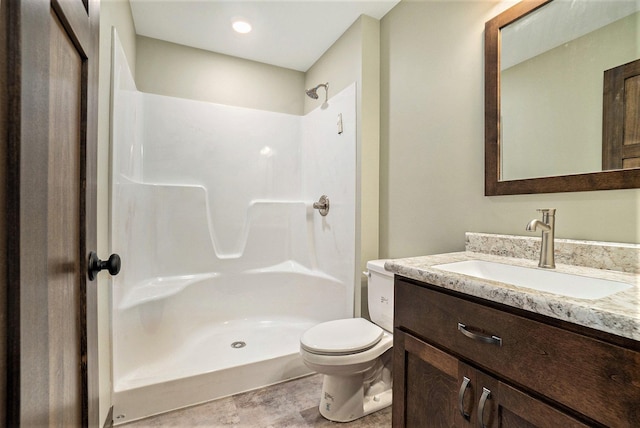 full bath featuring a stall shower, vanity, and toilet