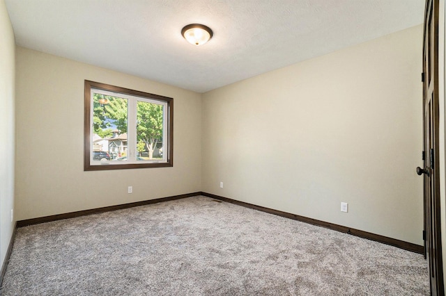 unfurnished room featuring light colored carpet and baseboards