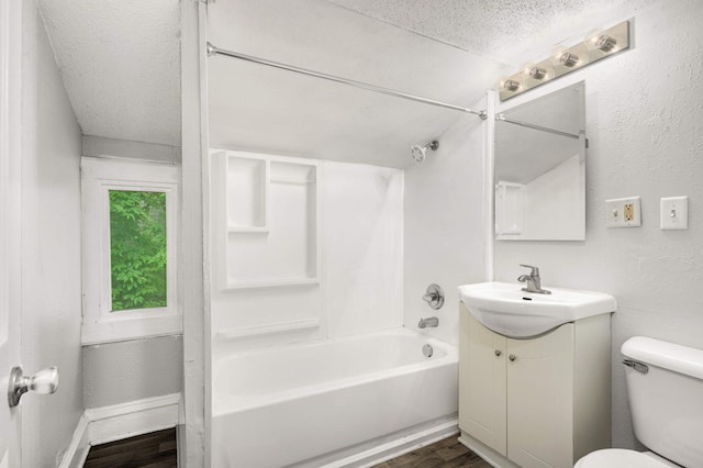 full bathroom featuring hardwood / wood-style floors, vanity, shower / bath combination, a textured ceiling, and toilet