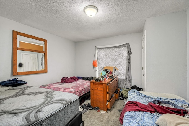 bedroom with light colored carpet and a textured ceiling