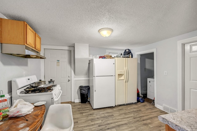 kitchen featuring a textured ceiling, white appliances, washer / clothes dryer, and light wood-type flooring