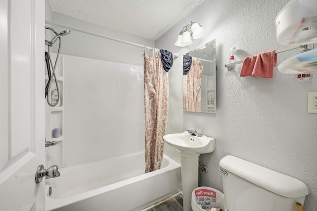 bathroom with a textured ceiling, shower / bath combo with shower curtain, and toilet