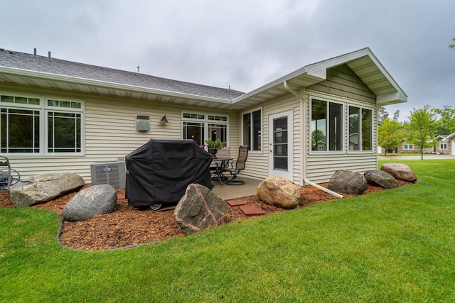 back of house with roof with shingles, a patio area, a yard, and central air condition unit