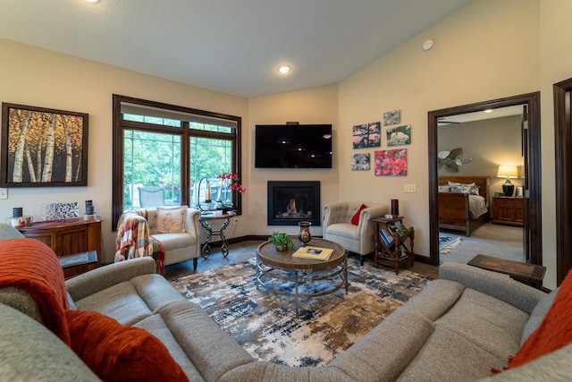 living room featuring recessed lighting, baseboards, vaulted ceiling, and a glass covered fireplace