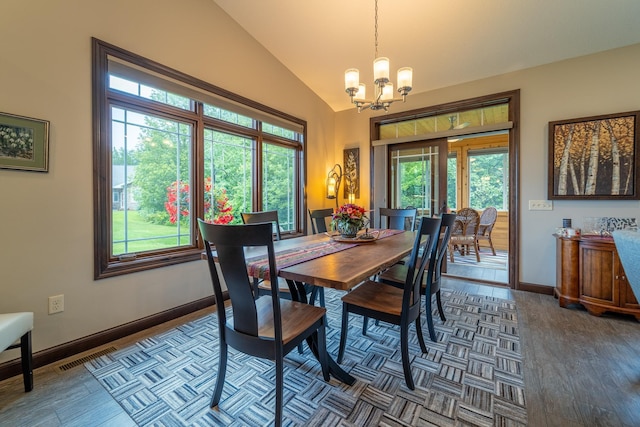 dining room featuring a notable chandelier, vaulted ceiling, baseboards, and wood finished floors