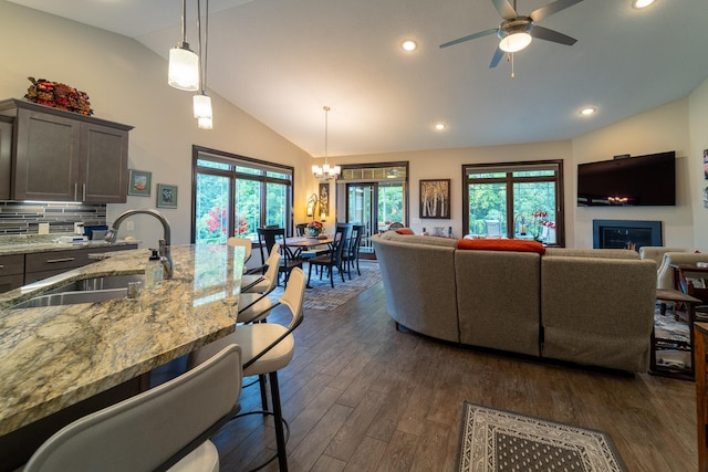 living area with recessed lighting, dark wood-style floors, plenty of natural light, and ceiling fan with notable chandelier