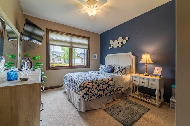 carpeted bedroom with ceiling fan and baseboards