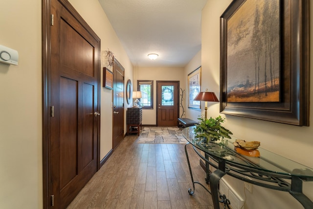 doorway featuring wood finished floors and baseboards