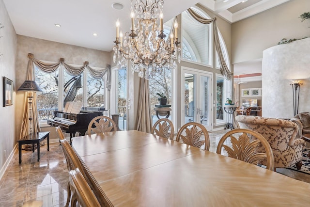 dining room with a towering ceiling, a chandelier, and a wealth of natural light