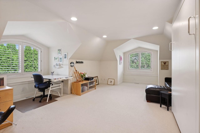 carpeted office with vaulted ceiling and a healthy amount of sunlight