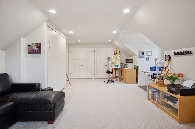 living area featuring lofted ceiling and carpet