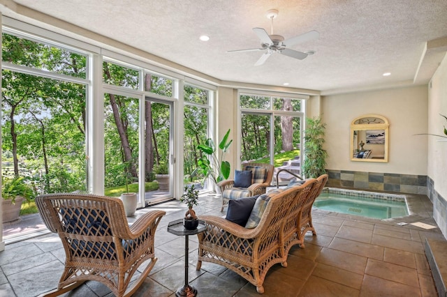 sunroom featuring ceiling fan and a hot tub