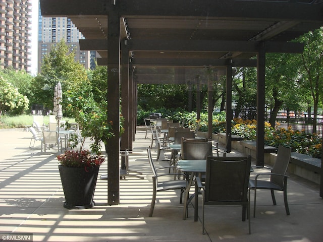 view of patio / terrace featuring fence and a city view