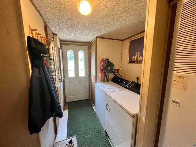 washroom featuring washer and dryer and a textured ceiling