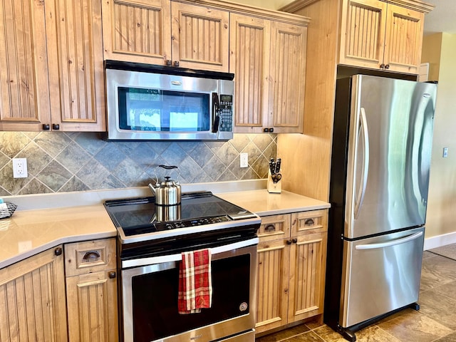 kitchen featuring stainless steel appliances, light brown cabinetry, and backsplash