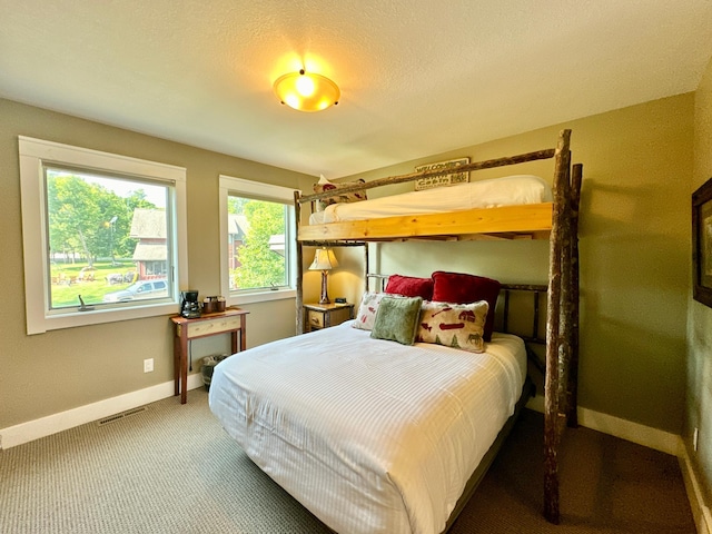 bedroom with a textured ceiling and carpet floors