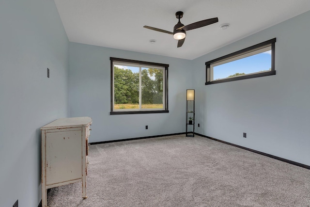 spare room with ceiling fan and light carpet