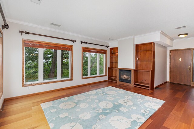 unfurnished living room featuring dark wood finished floors, visible vents, crown molding, and baseboards