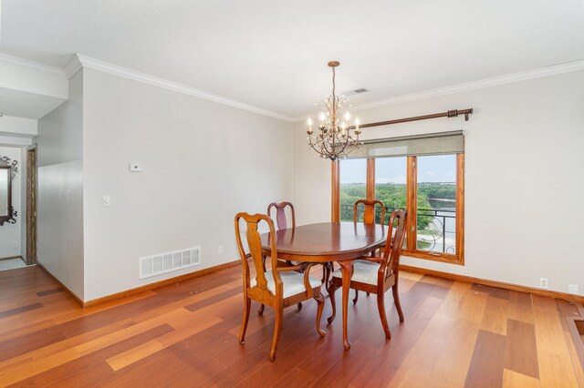 dining room featuring baseboards, visible vents, an inviting chandelier, crown molding, and light wood-type flooring