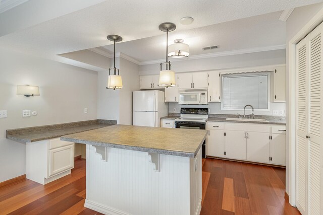 kitchen featuring visible vents, white cabinets, white appliances, and a sink