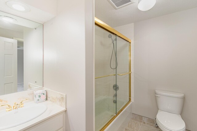bathroom featuring visible vents, toilet, a textured ceiling, shower / bath combination with glass door, and vanity