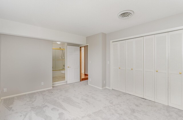 unfurnished bedroom with baseboards, visible vents, carpet floors, a closet, and connected bathroom