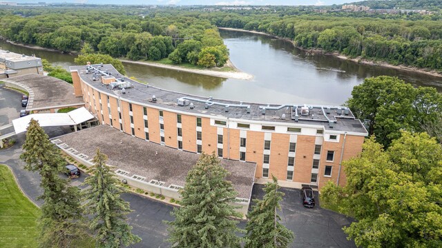 bird's eye view featuring a wooded view and a water view