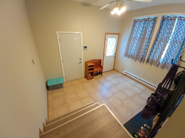 entrance foyer with a baseboard heating unit, ceiling fan, and light tile patterned flooring