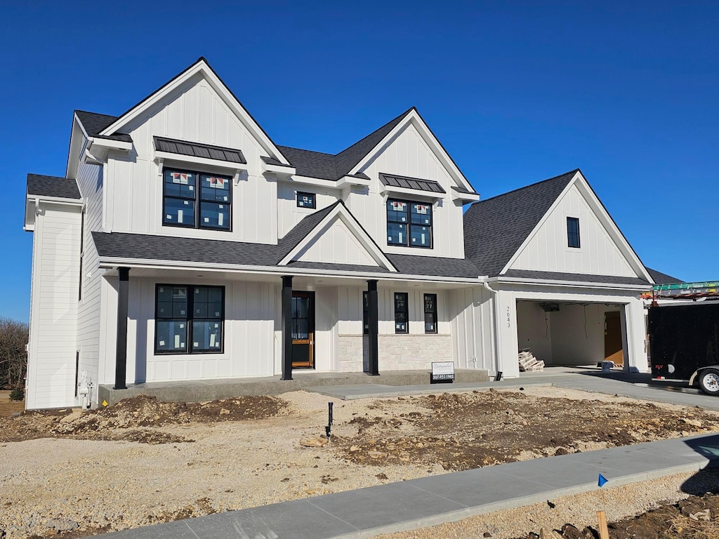 modern farmhouse style home featuring covered porch and a garage