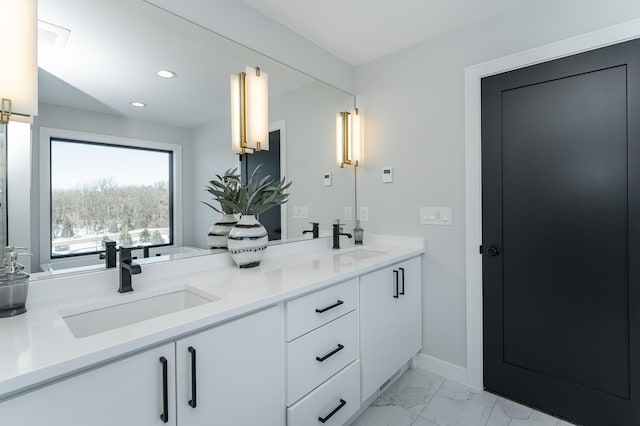 bathroom featuring double vanity, marble finish floor, a sink, and recessed lighting