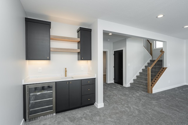 bar with wine cooler, stairway, a sink, wet bar, and baseboards