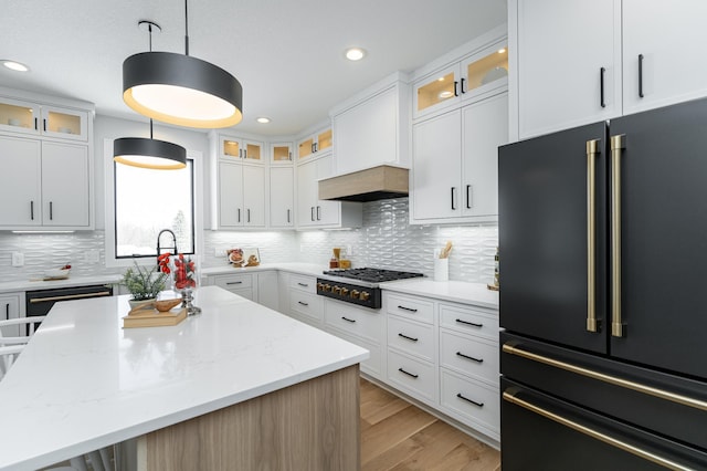 kitchen with gas cooktop, light wood-style flooring, white cabinets, high quality fridge, and tasteful backsplash