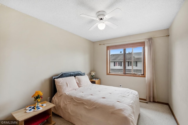 carpeted bedroom with a textured ceiling and ceiling fan