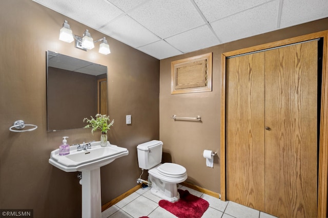 bathroom with a paneled ceiling, toilet, and tile patterned floors