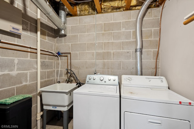 clothes washing area featuring washer and clothes dryer and sink