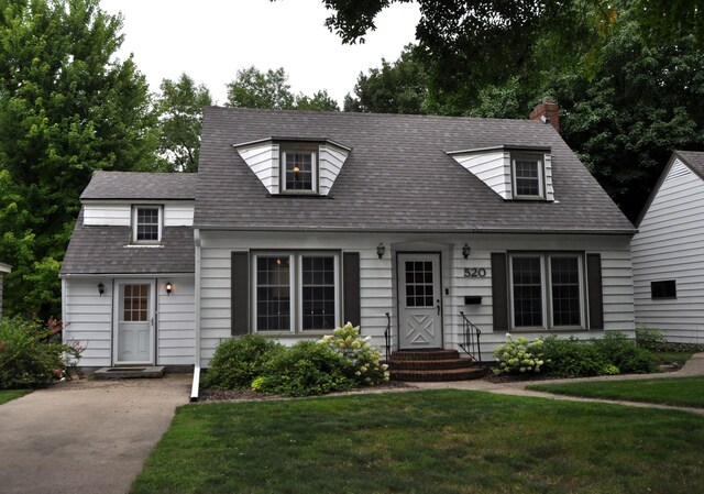 cape cod home with a front yard