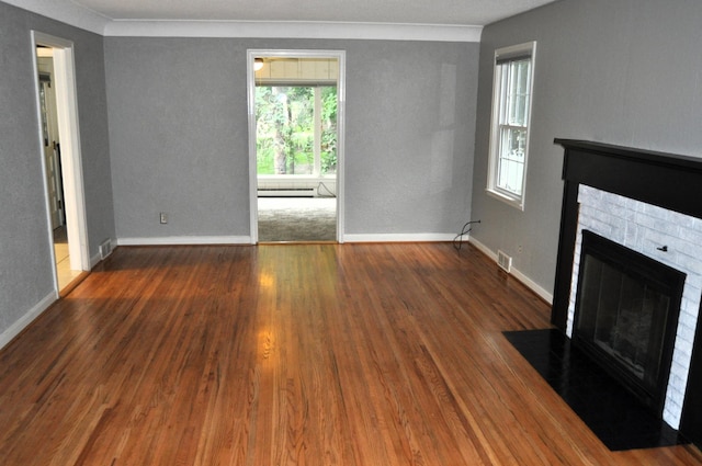 unfurnished living room with baseboard heating, dark wood-type flooring, and crown molding