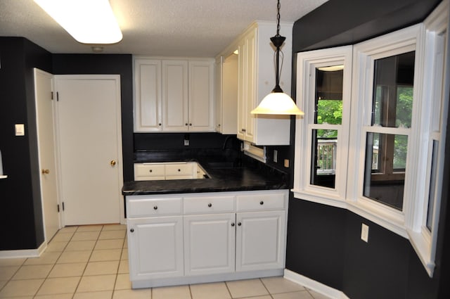 kitchen with hanging light fixtures, light tile patterned floors, and white cabinets