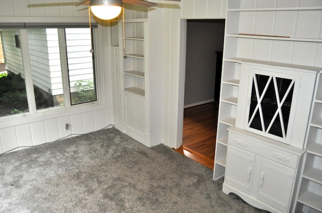 unfurnished dining area featuring dark carpet