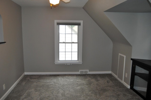 bonus room with dark carpet, lofted ceiling, and ceiling fan