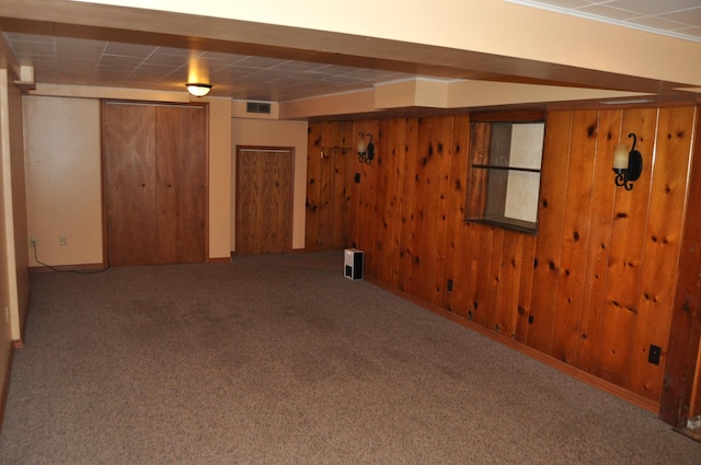 basement with carpet and wooden walls