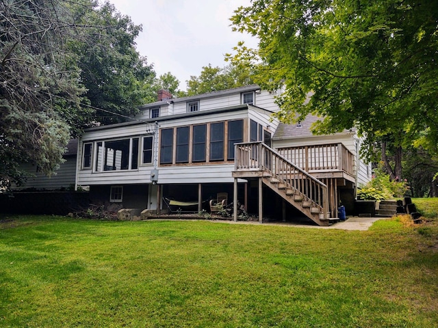 back of house with a sunroom, a lawn, and a wooden deck