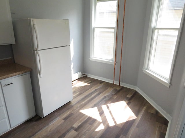 kitchen featuring white cabinets, dark hardwood / wood-style floors, and white fridge