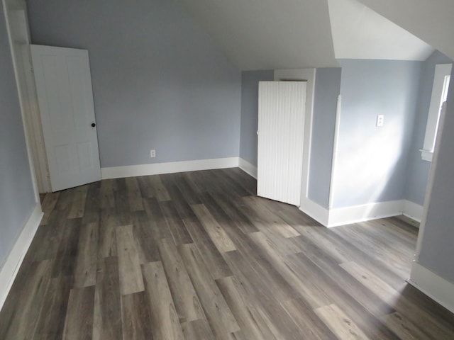 bonus room featuring vaulted ceiling and dark wood-type flooring